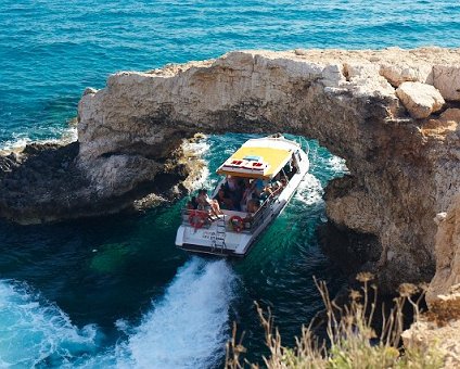 _DSC0014 Boat passing under a natural bridge at the sea caves.