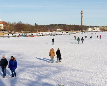 _DSC0088 People going for a walk on the lake in the sunny winter weather. The Kaknäs tower in the background.